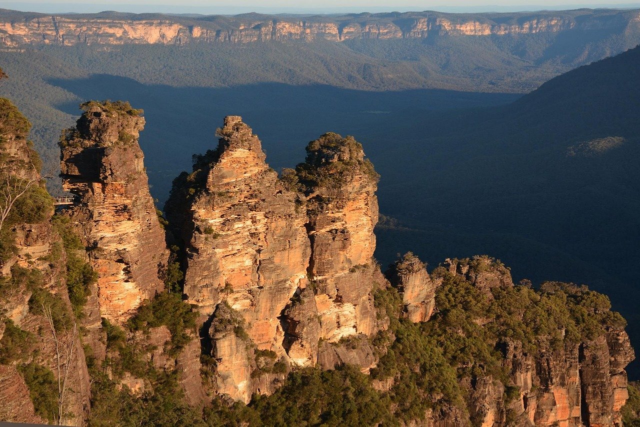 Scenisk vy över Three Sisters klippformation i Blue Mountains National Park, Australien under solnedgången med frodig grönska