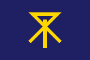 Mörkblå flagga med gul abstrakt geometrisk symbol Flagga med en mörkblå bakgrund och en unik gul geometrisk symbol som liknar en abstrakt runa eller bokstav i mitten