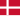 Närbild av en person som håller ett litet vitt piller mellan tumme och pekfinger mot en blå bakgrund