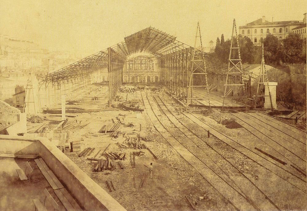 Järnvägsstation under konstruktion med stålskelett och spår Historiskt sepiafoto av en stor järnvägsstation under konstruktion med stålskelett och flera järnvägsspår