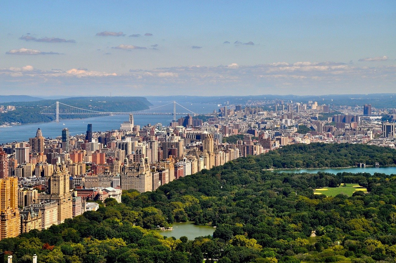 Flygfoto av Central Park med omgivande Manhattan skyline och George Washington Bridge i New York City på en klar dag