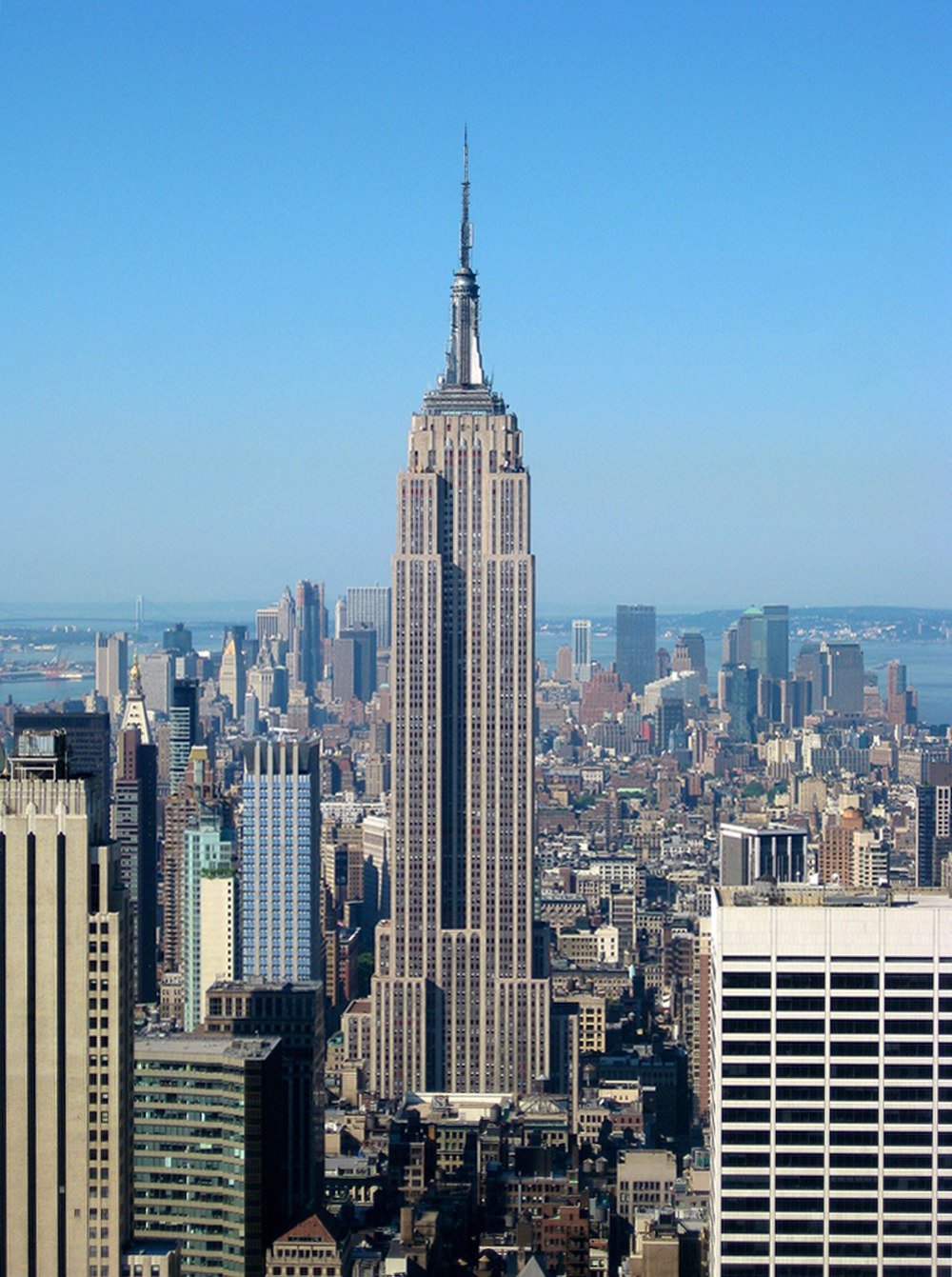 Empire State Building i New York Citys skyline Empire State Building som reser sig över New York Citys skyline på en klar solig dag med blå himmel i bakgrunden