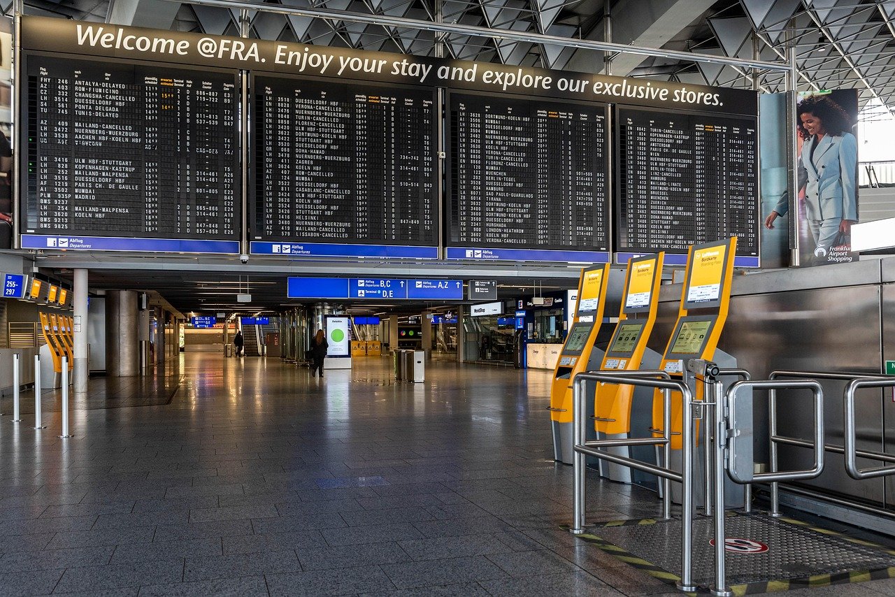 Frankfurt flygplats avgångshall med flyginformationsskärmar och självbetjäningsincheckningskiosker