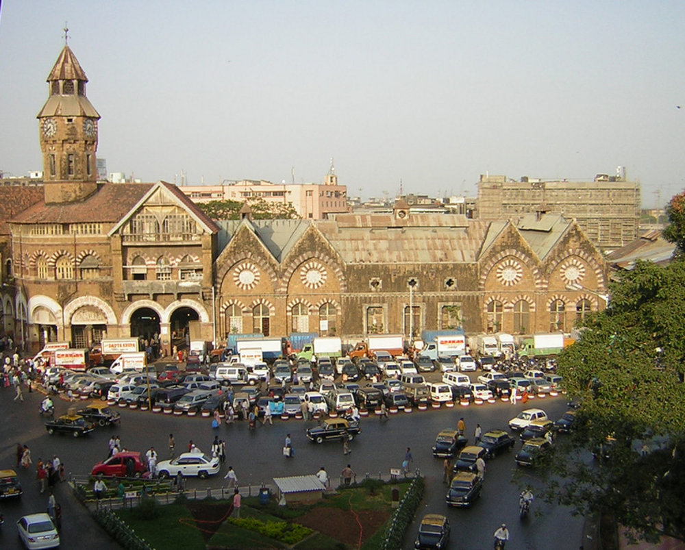 Mumbai CST Railway Station och Trafik Historiska Mumbai CST järnvägsstation med vintagearkitektur och livlig trafik framför, en stor transportknutpunkt i Indien