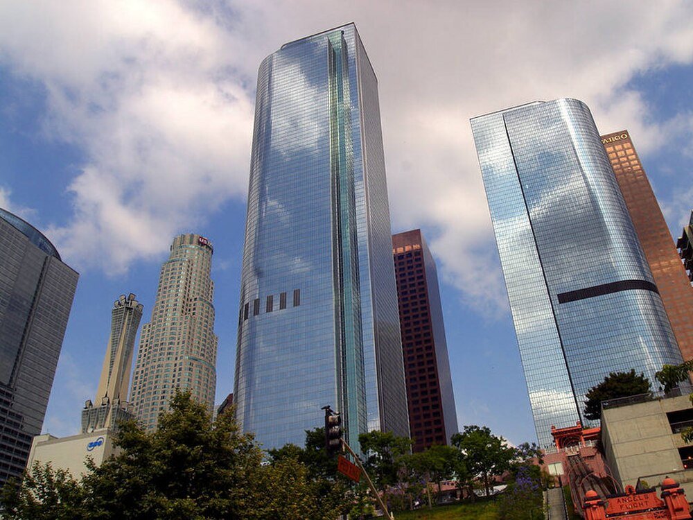 Downtown Los Angeles moderna skyskrapor skyline Downtown Los Angeles skyline med moderna glashöghus under en delvis molnig himmel med träd i förgrunden