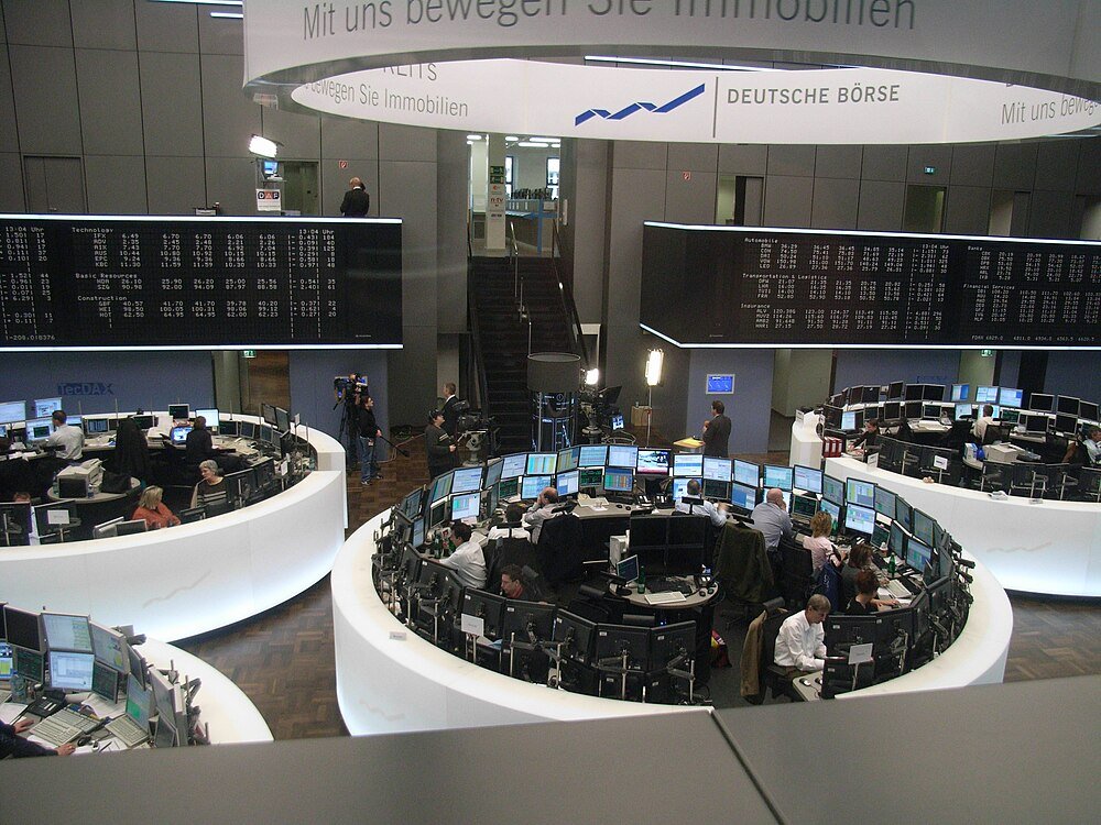 Deutsche Börse handelsgolv med aktiekursdisplayer Handlare som arbetar på Deutsche Börse börs med flera skärmar och stora elektroniska aktiekursdisplayer