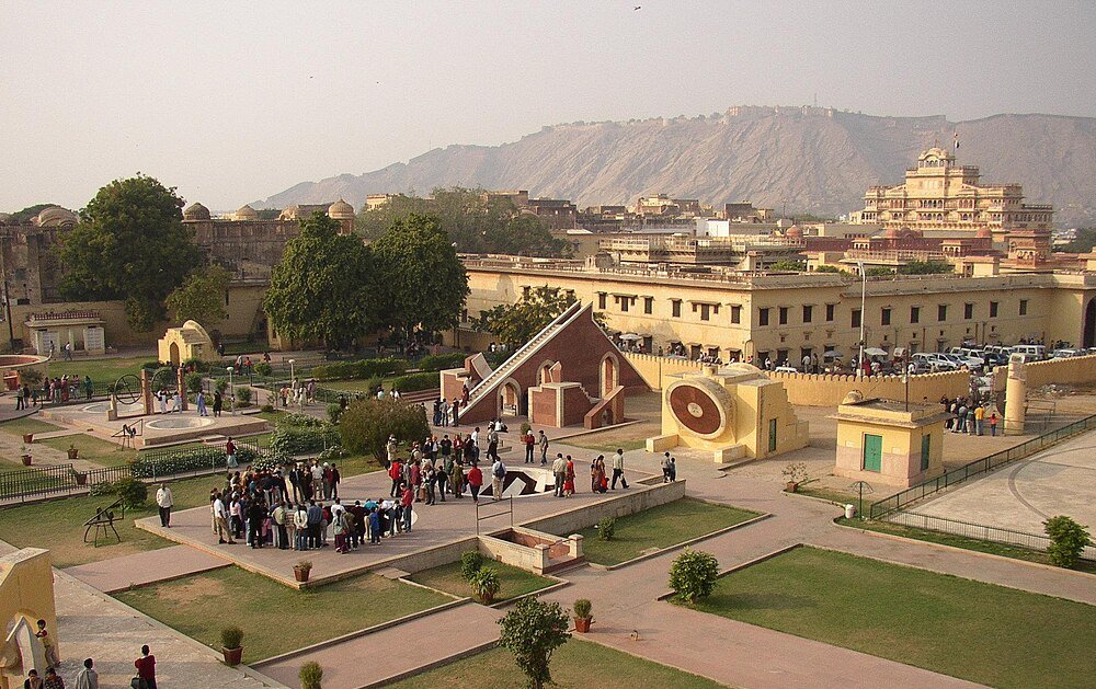 Jantar Mantar Observatorium i Jaipur med turister Jantar Mantar astronomiska instrument och observatorium med turister i Jaipur, Rajasthan, Indien med Aravalli-bergen i bakgrunden