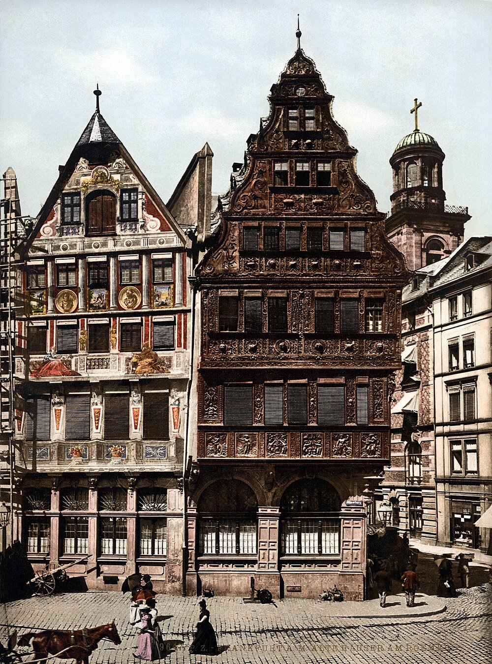 Historiska korsvirkeshus i Frankfurt am Main Historiska korsvirkeshus med intrikata träskärningar i Frankfurt am Main, Tyskland, med kullerstensgata och fotgängare