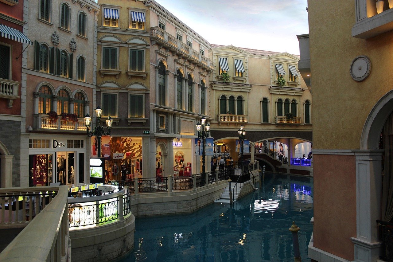 Venetiansk stil inomhus shoppingcenter med kanal och butiker Inomhus shoppingcenter med venetiansk stil kanal, broar och europeisk arkitektur med butiker och gatlyktor