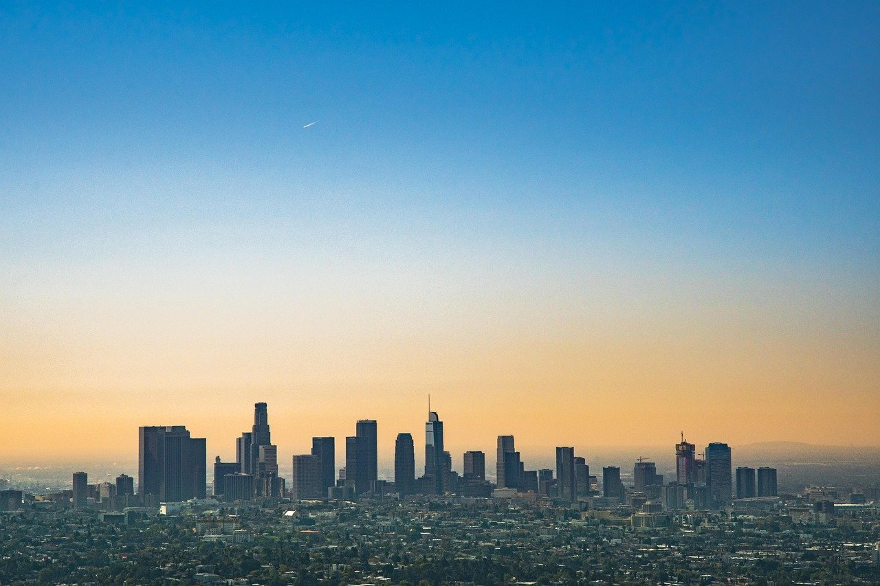 Panoramavy över downtown Los Angeles skyline med höghus under en klarblå himmel vid solnedgången