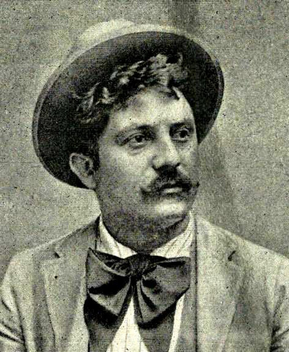 Vintage porträtt av man med fluga och hatt Vintage svartvitt porträtt av en man med mustasch som bär fluga och hatt, tidigt 1900-tals stil