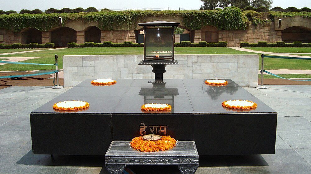 Raj Ghat Minnesmärke med Ringblomma Kransar Raj Ghat minnesmärke i Delhi Indien med svart marmorskiva och orange ringblomma kransar