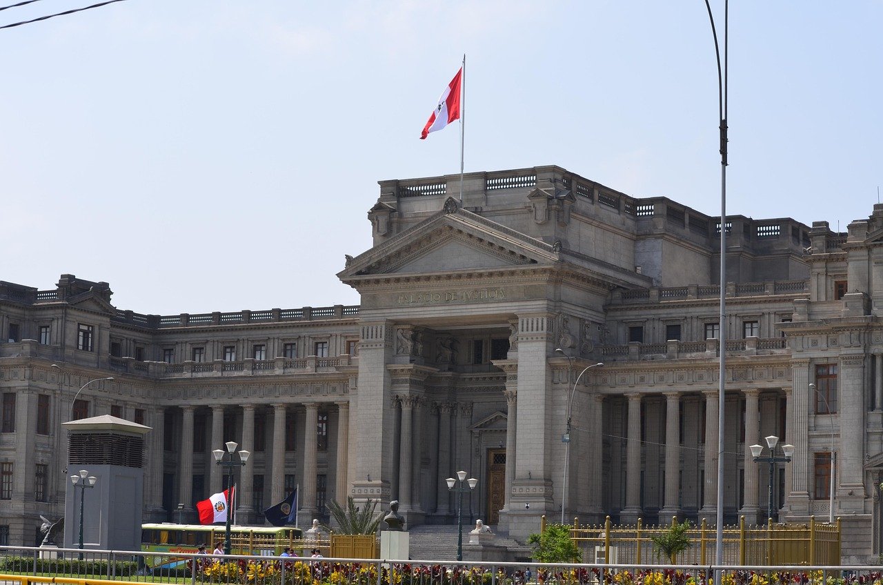 Palacio de Justicia-byggnaden i Lima, Peru med peruansk flagga och klassisk arkitektur under klar himmel