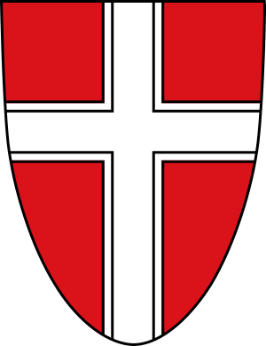 Röd sköld med vitt dubbelkantat kors emblem Röd sköld med ett vitt dubbelkantat korssymbol, som representerar ett heraldiskt emblem eller vapensköldsdesign.