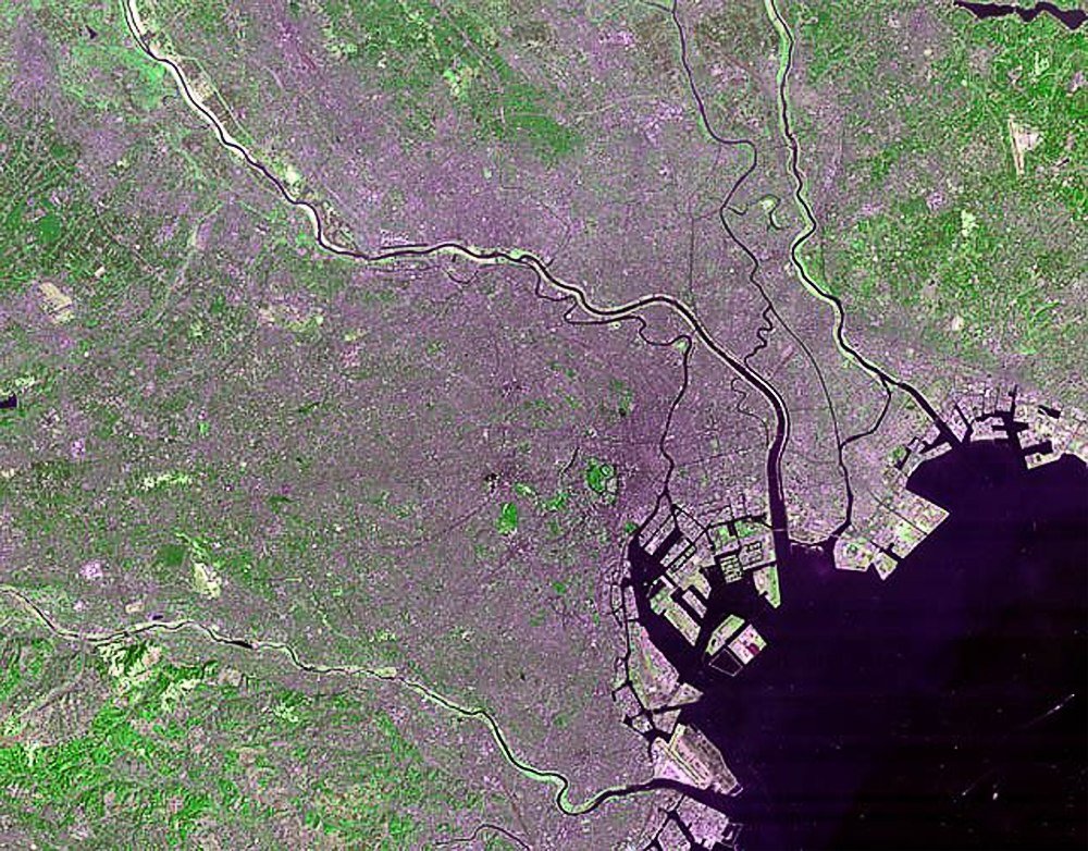 Satellitbild av kuststad med floder och urbana områden Satellitvy av en kuststad med floder, urbana områden och grön vegetation som visar detaljerade land- och vattenfunktioner