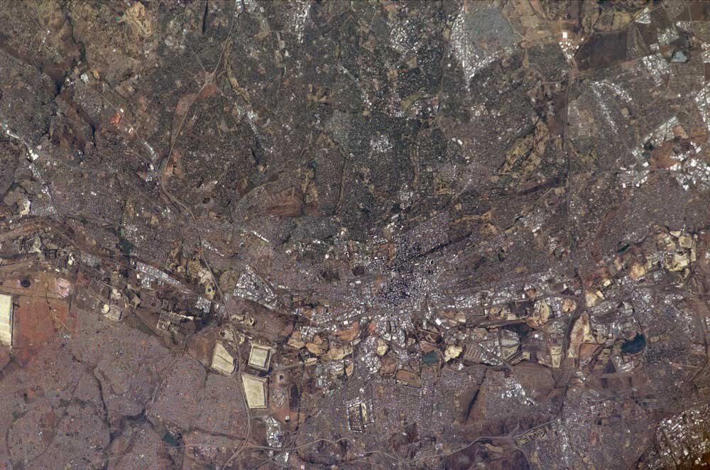 Satellitvy av tät urban stadsmiljö Satellitvy av en tätbefolkad urban miljö med vägar, byggnader och öppna landytor