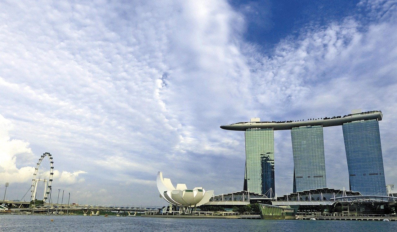 Marina Bay Sands hotell och Singapore Flyer pariserhjul med molnig himmel över Marina Bay strandlinje