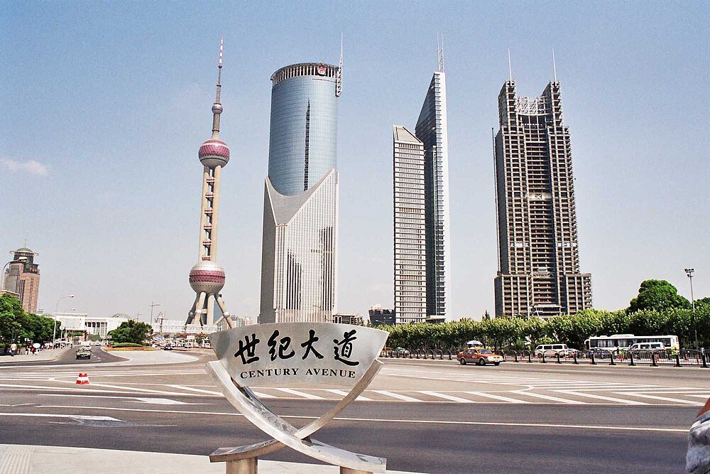 Century Avenue Shanghai skyline med Oriental Pearl Tower Century Avenue i Shanghai med ikoniska moderna skyskrapor och Oriental Pearl Tower under klarblå himmel
