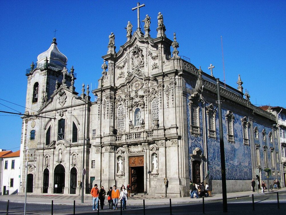 Barockkyrka med blå kakelmålningar Barockkyrka med utsmyckad stenfasad och blå kakelmålningar under klarblå himmel i en europeisk stad