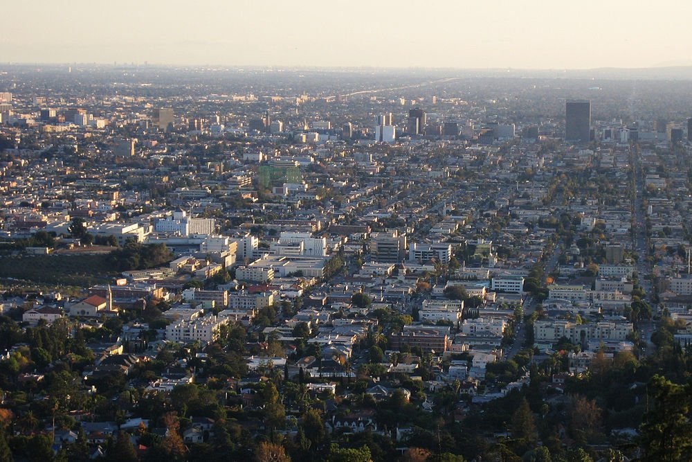 Urban stadsbild flygfoto vid solnedgången Flygfoto av en vidsträckt urban stadsbild med täta byggnader och gator under en klar himmel vid solnedgången