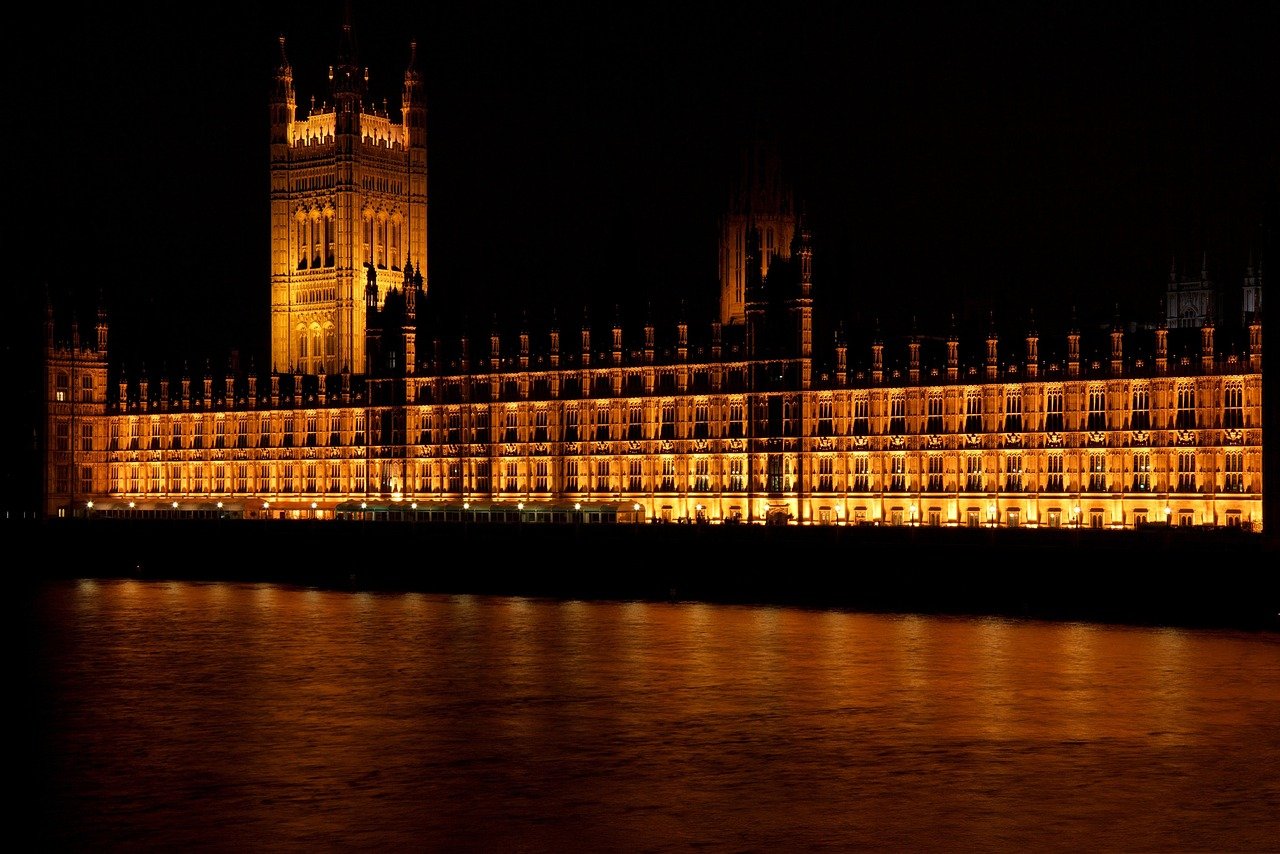 Upplyst Palace of Westminster på natten som speglas i Themsen i London, ikoniskt brittiskt landmärke och regeringsbyggnad