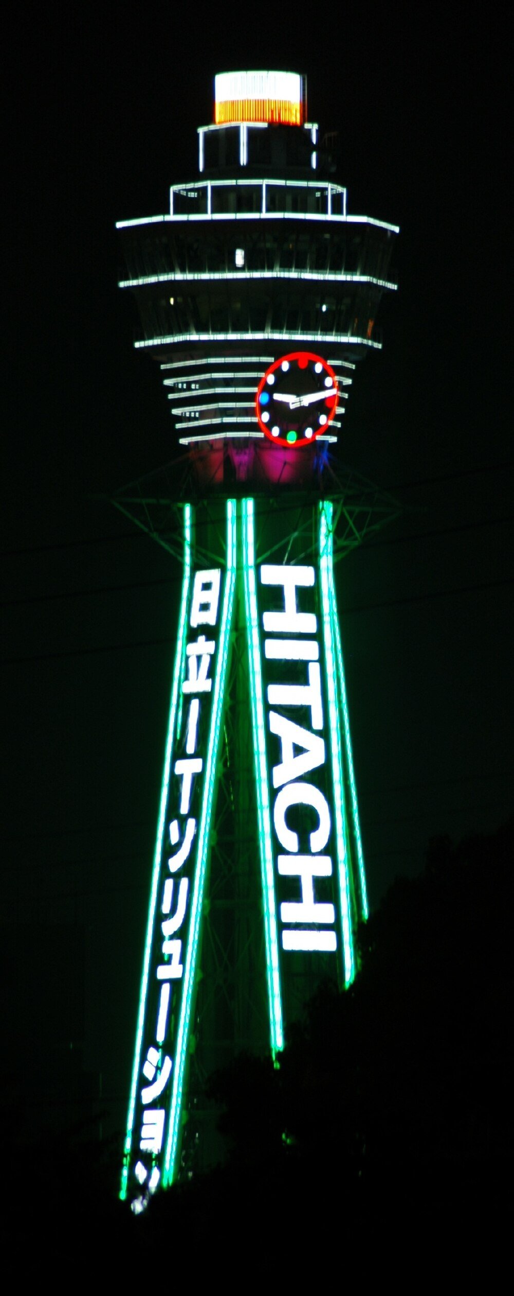 Tsutenkaku-tornet Osaka Hitachi Neonljus Nattvy av Tsutenkaku-tornet i Osaka, Japan upplyst med Hitachi-neonljus och en färgglad klocka.