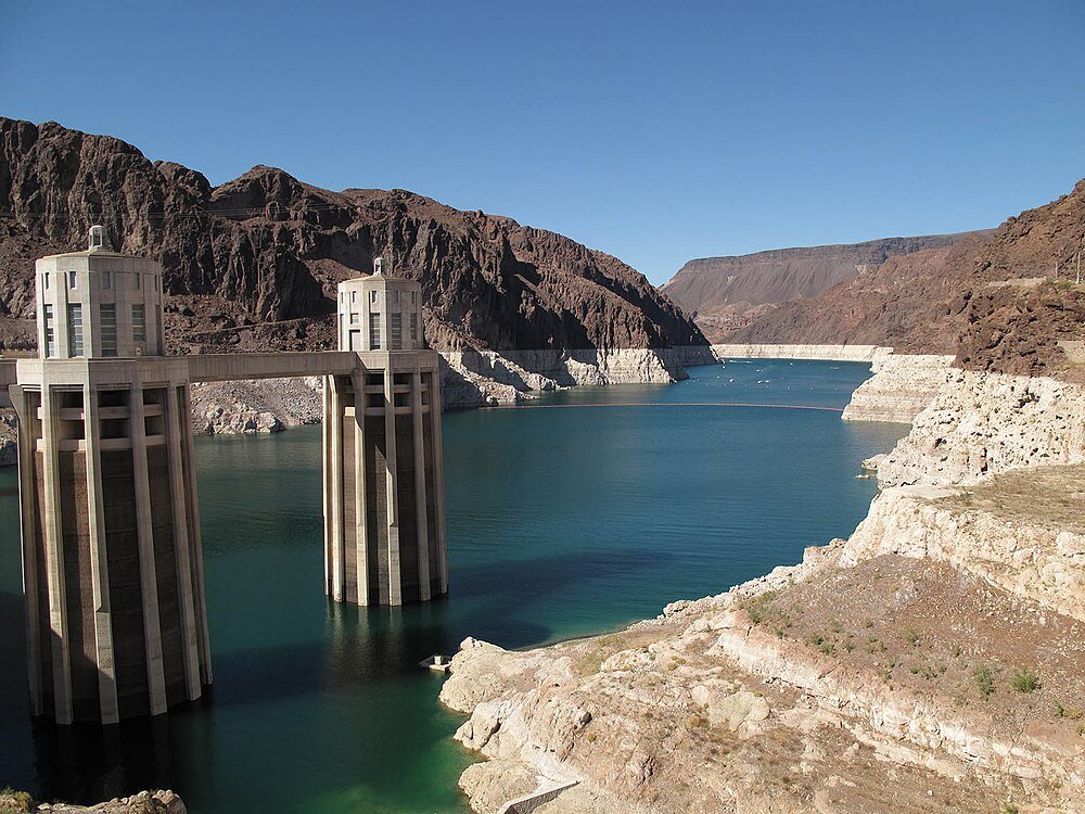 Hoover Dam intagstorn och reservoarvy Hoover Dam intagstorn med vattenreservoar och stenig ökenlandskap under klarblå himmel