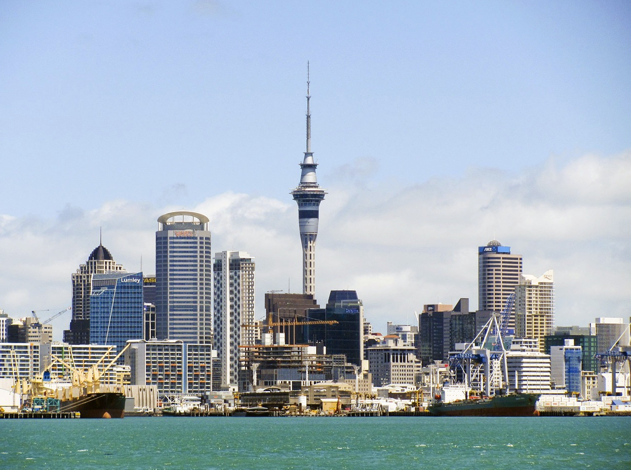 Auckland stadsbild med Sky Tower och strandlinje Auckland stadsbild med Sky Tower, strandlinje och lastfartyg under en klarblå himmel i Nya Zeeland