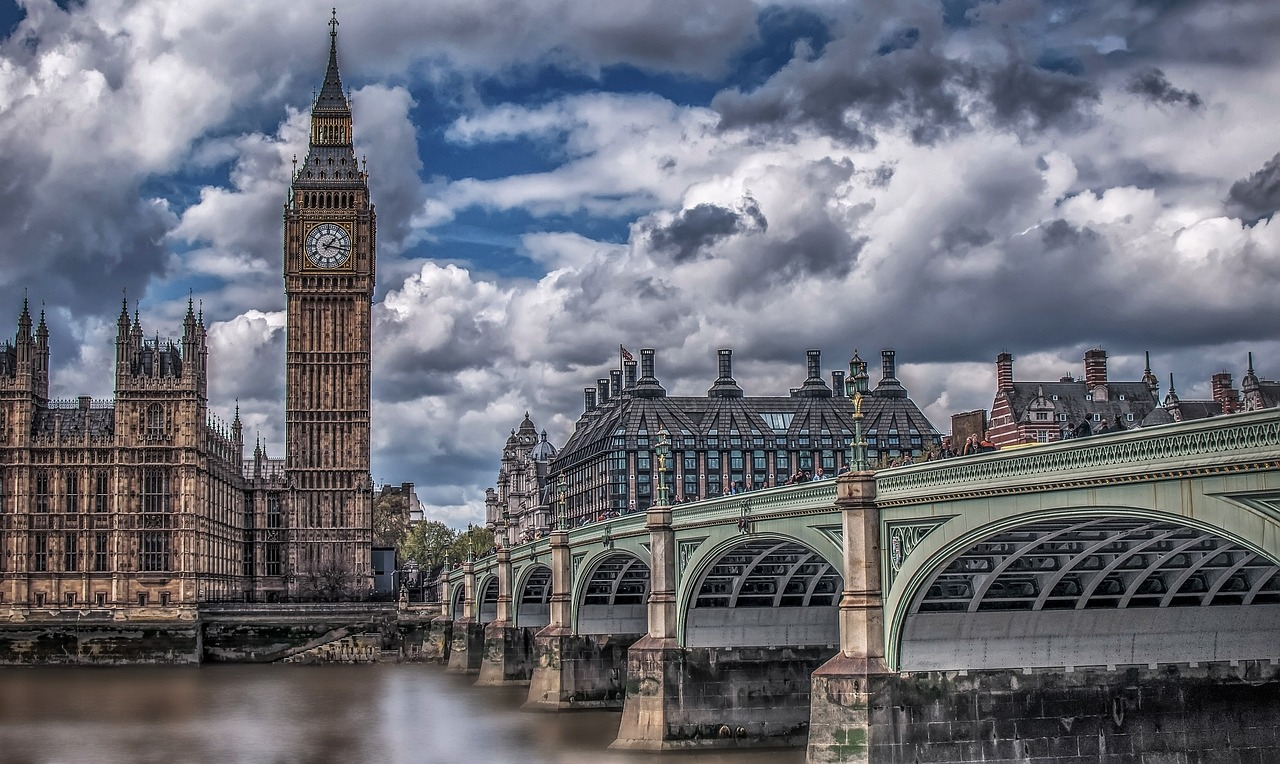 Big Ben och Westminster Bridge i London Big Ben klocktorn och Westminster Bridge över Themsen i London med dramatisk molnig himmel i bakgrunden