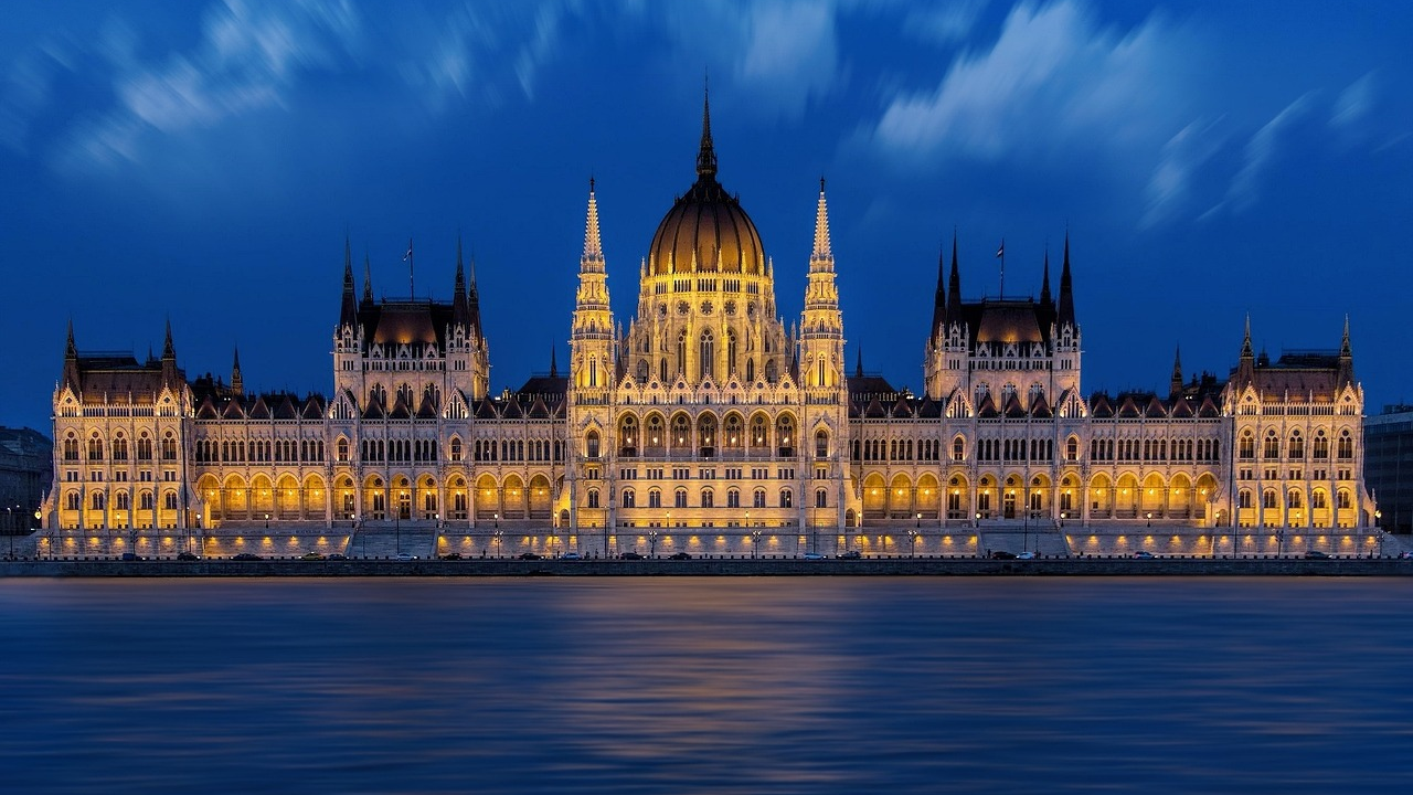 Ungerska parlamentsbyggnaden på natten i Budapest Upplyst ungersk parlamentsbyggnad på natten med blå himmel och Donau i Budapest, Ungern