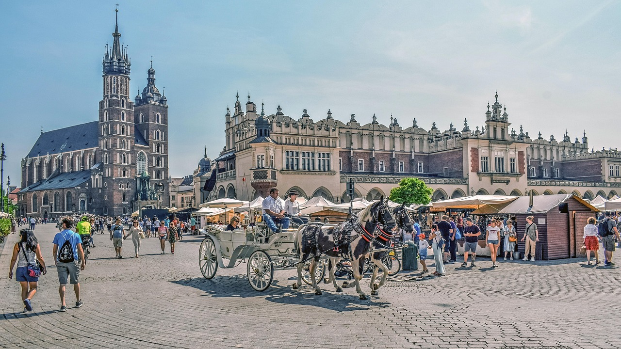 Historiskt stadstorg med hästvagn och turister Historiskt europeiskt stadstorg med hästdragen vagn, turister och gotisk arkitektur under klar himmel