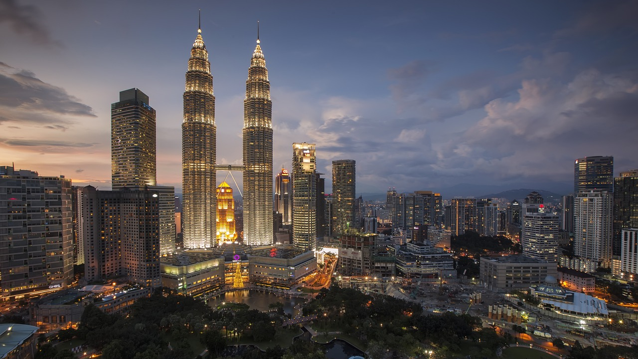 Kuala Lumpurs stadssilhuett med Petronas Twin Towers på natten Nattvy av Kuala Lumpurs stadssilhuett med upplysta Petronas Twin Towers och omgivande skyskrapor