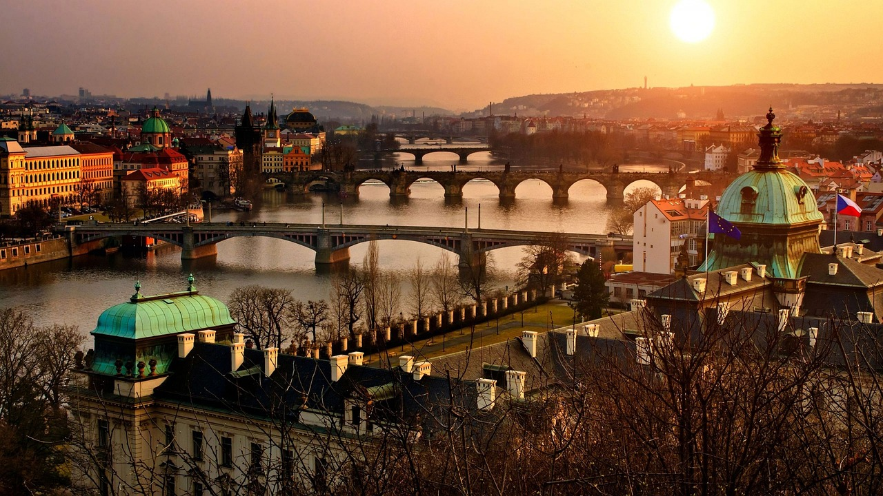 Prags stadsbild med Vltavafloden och broar vid solnedgången Scenisk vy över Prag med Vltavafloden och historiska broar vid solnedgången, med ikonisk arkitektur och varm belysning