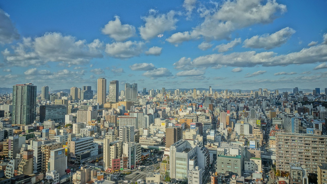 Urban stadsbild med höghus och blå himmel Panoramautsikt över en tät urban stadsbild med höghus under en blå himmel med spridda moln