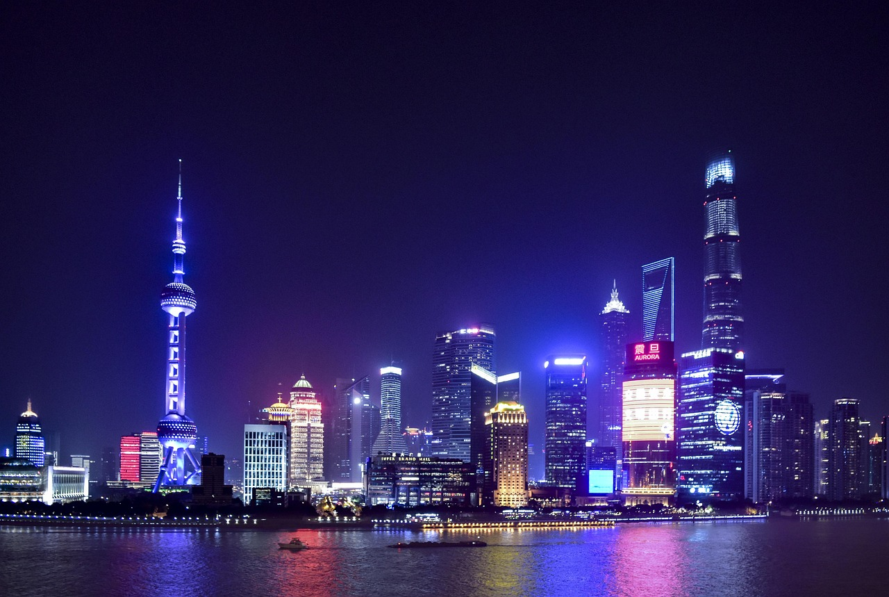 Shanghais skyline på natten med lysande skyskrapor Nattvy av Shanghais skyline med upplysta skyskrapor och reflektioner på Huangpu-floden