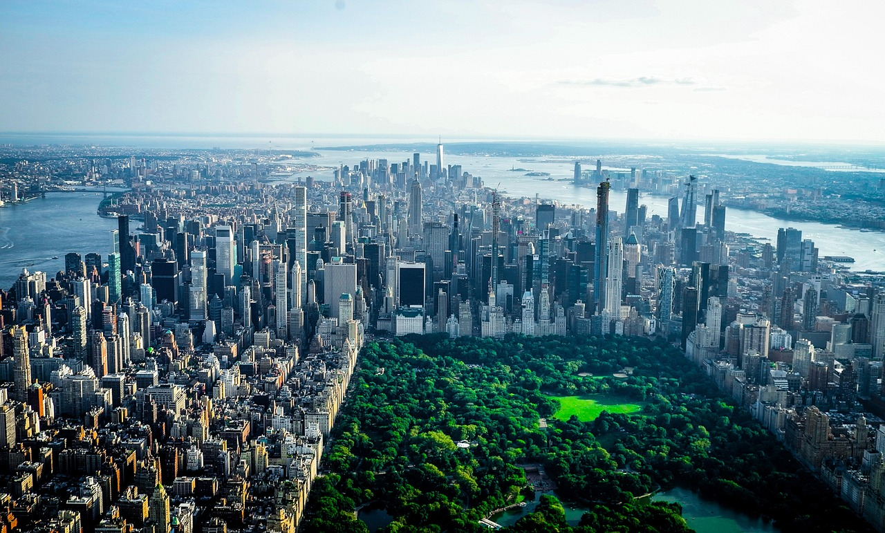 Flygfoto av Central Park och Manhattans skyline Flygfoto av Central Park omgivet av skyskrapor i Manhattan, New York City med floder i bakgrunden