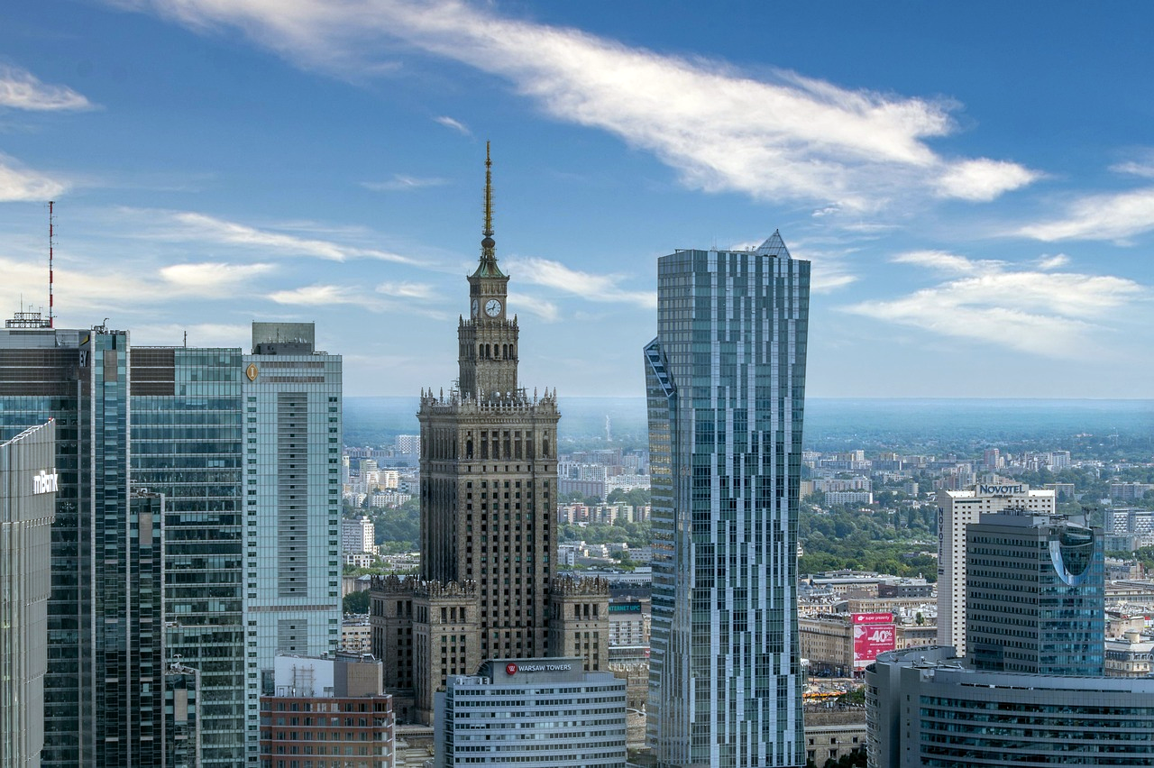 Warszawas silhuett med Kultur- och vetenskapspalatset Silhuett av Warszawa med moderna skyskrapor och det historiska Kultur- och vetenskapspalatset under en blå himmel