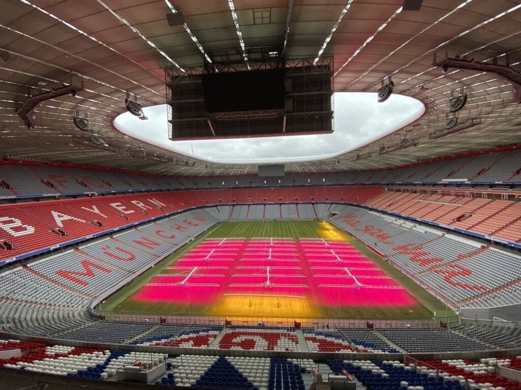 Inuti Allianz Arena, FC Bayern Münchens hemmaarena, med stigande läktare runt planen