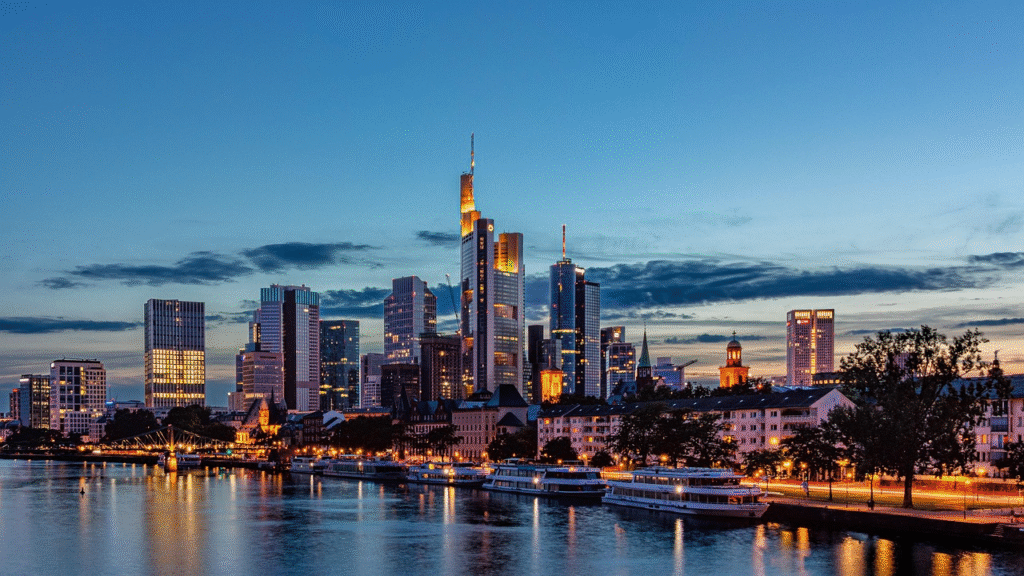 Frankfurts silhuett — 'Mainhattan' — speglad i floden Main i skymningen