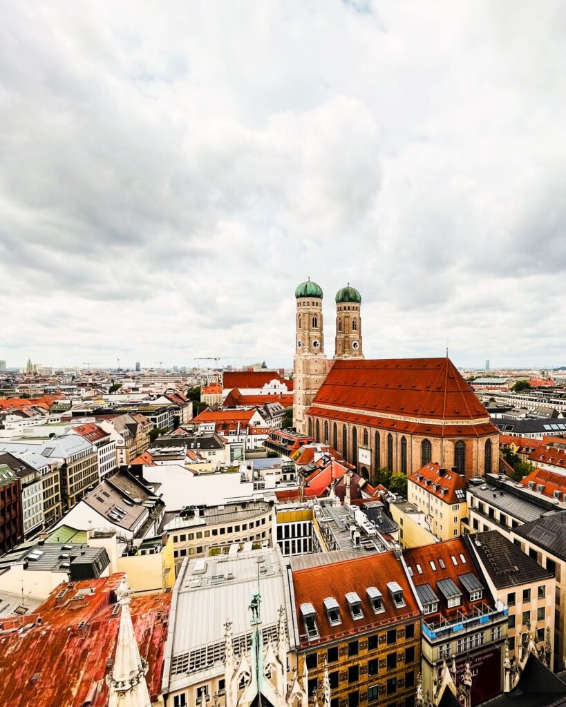 Aerial view of central Munich with the twin onion-domed towers of the Frauenkirche rising above the Old Town's red rooftops